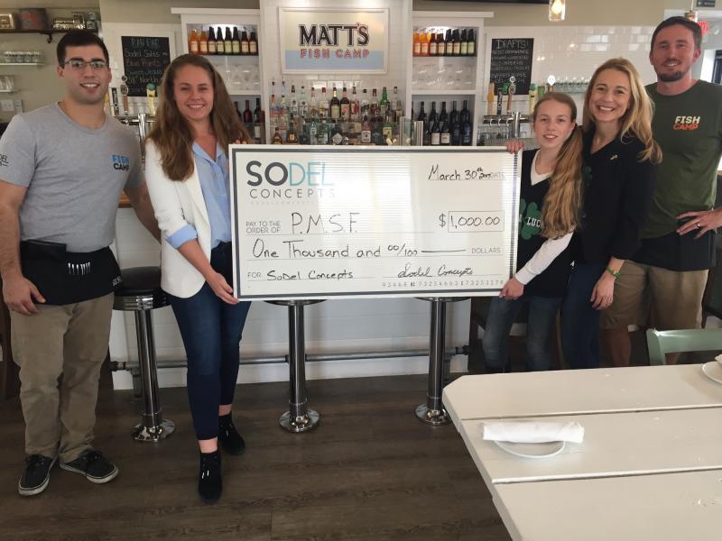 Matt's Fish Camp in Lewes, part of the SoDel Concepts hospitality group, donated $1,000 to the Phelan-McDermid Syndrome Foundation, which advocates for those with a rare chromosome disorder. Shown are (l-r) server Kyle McCoy; Lindsey Barry, controller for SoDel Concepts; Elle Nauman of Lewes, who has Phelan-McDermid Syndrome; Elle's mother Jenny Nauman; and server Corey Mahoney. SUBMITTED PHOTO